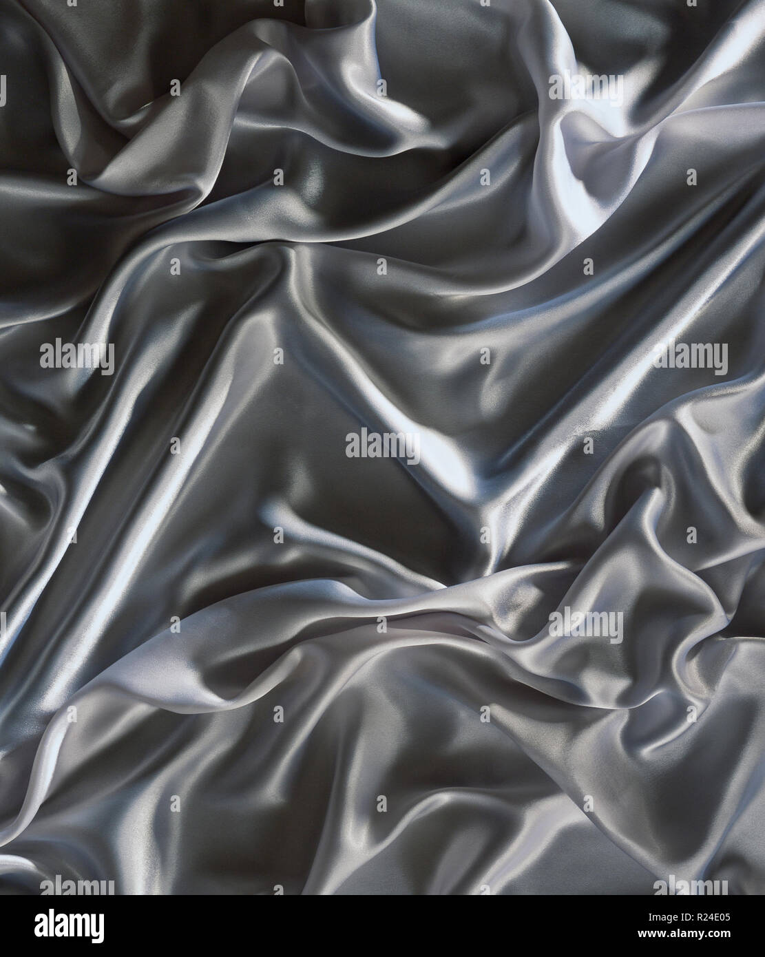 Argento stropicciata tessuto satin sfondo che mostra i progressi compiuti in una curva Foto Stock