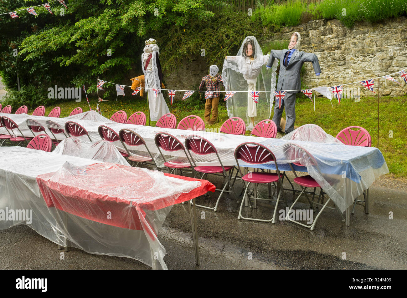 Tavoli immersi nella pioggia spaventano gli effetti della famiglia reale durante una festa di strada per il compleanno ufficiale della regina Elisabetta II del 90th Foto Stock