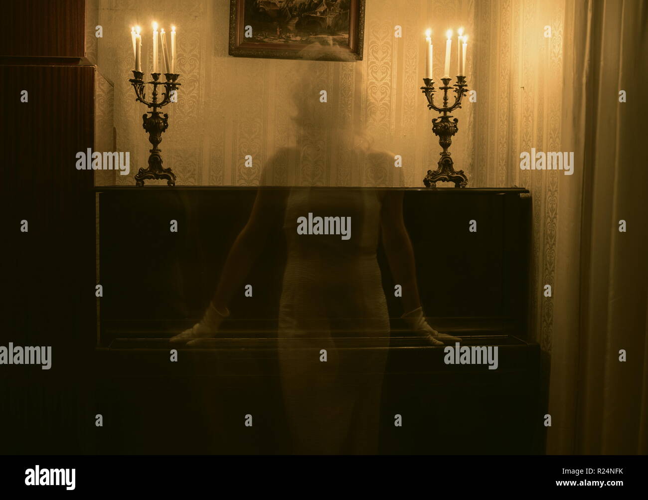 Fantasma della donna in camera con candele Foto Stock