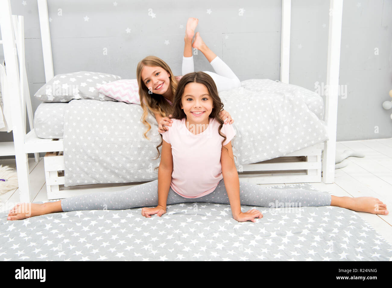 Tempo per la serata di stretching. Carino pratica ginnasta split con un  amico. Ragazza bambino sedersi diviso in camera da letto. Amici ginnasti  supportano a vicenda. Regime Sport stile di vita. Ragazza