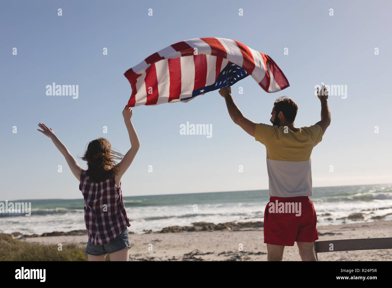 Giovane Azienda bandiera americana sulla spiaggia Foto Stock