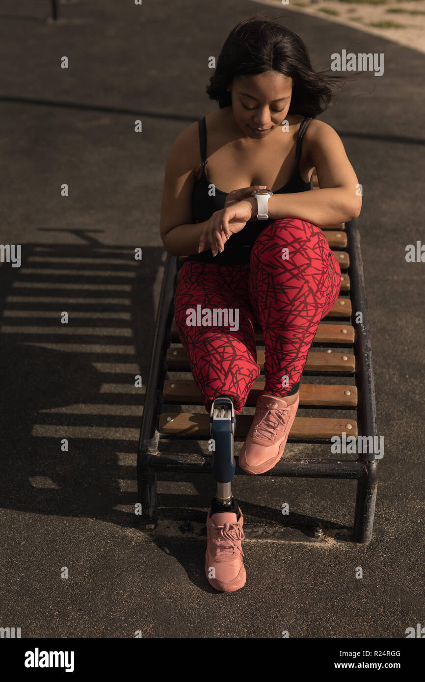 Donna disabile utilizzando smartwatch Foto Stock