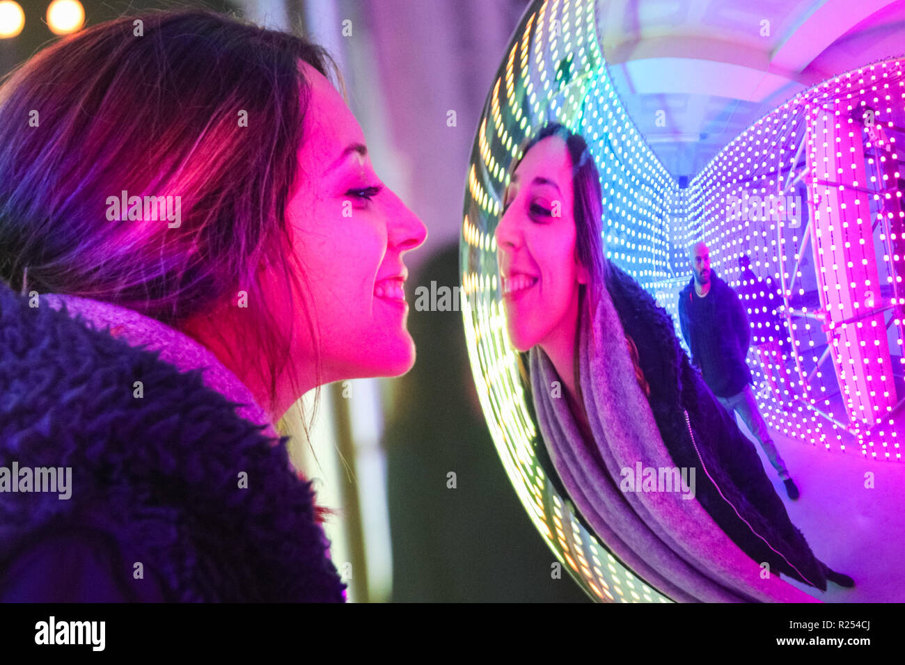 Regent Street, Londra, Regno Unito, 16 Nov 2018. I visitatori hanno divertimento prendendo selfies, guardando le loro riflessioni e la loro posa con la luce colorata di installazioni. Luci di Mulberry è una serie di illuminazione di esperienze interattive che celebrare come luci, colori, forme e le persone si incontrano per creare un moderno britannico di Natale. Esso funziona a 100 Regent Street fino a nov 18 Credito: Imageplotter News e sport/Alamy Live News Foto Stock