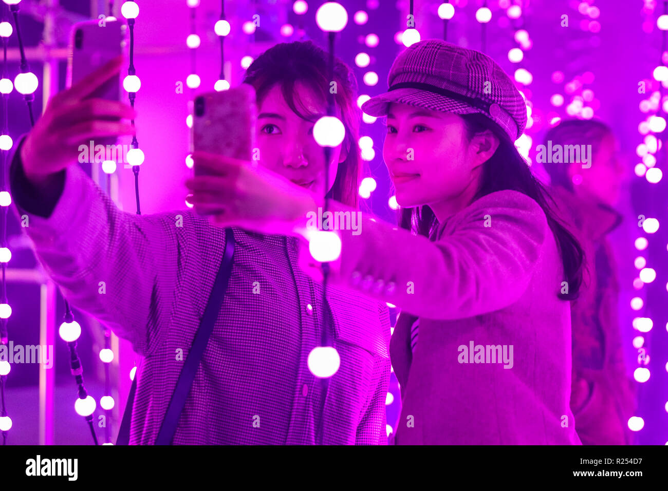 Regent Street, Londra, Regno Unito, 16 Nov 2018. I visitatori hanno divertimento prendendo selfies, guardando le loro riflessioni e la loro posa con la luce colorata di installazioni. Luci di Mulberry è una serie di illuminazione di esperienze interattive che celebrare come luci, colori, forme e le persone si incontrano per creare un moderno britannico di Natale. Esso funziona a 100 Regent Street fino a nov 18 Credito: Imageplotter News e sport/Alamy Live News Foto Stock