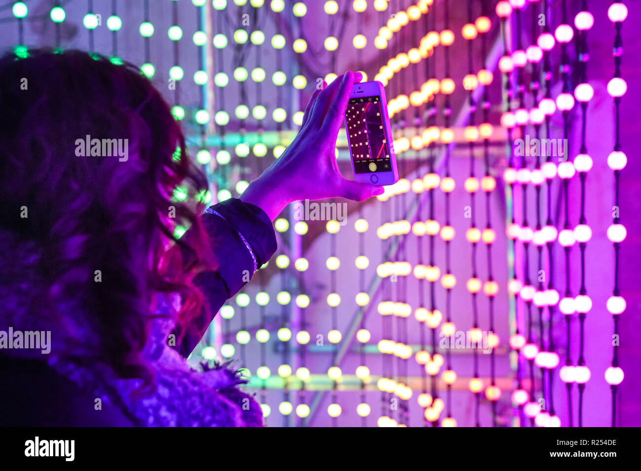 Regent Street, Londra, Regno Unito, 16 Nov 2018. I visitatori hanno divertimento prendendo selfies, guardando le loro riflessioni e la loro posa con la luce colorata di installazioni. Luci di Mulberry è una serie di illuminazione di esperienze interattive che celebrare come luci, colori, forme e le persone si incontrano per creare un moderno britannico di Natale. Esso funziona a 100 Regent Street fino a nov 18 Credito: Imageplotter News e sport/Alamy Live News Foto Stock