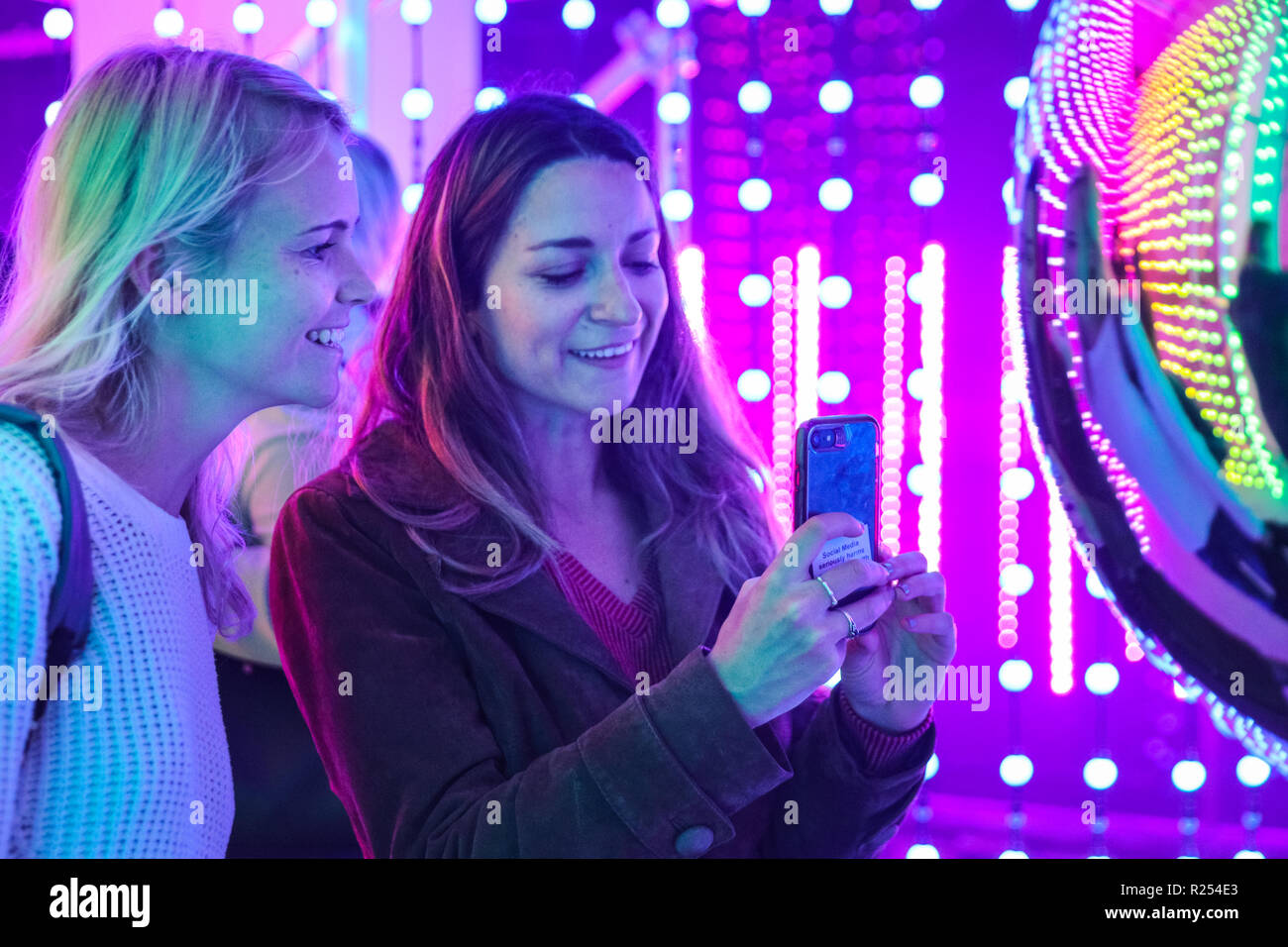 Regent Street, Londra, Regno Unito, 16 Nov 2018. I visitatori hanno divertimento prendendo selfies, guardando le loro riflessioni e la loro posa con la luce colorata di installazioni. Luci di Mulberry è una serie di illuminazione di esperienze interattive che celebrare come luci, colori, forme e le persone si incontrano per creare un moderno britannico di Natale. Esso funziona a 100 Regent Street fino a nov 18 Credito: Imageplotter News e sport/Alamy Live News Foto Stock