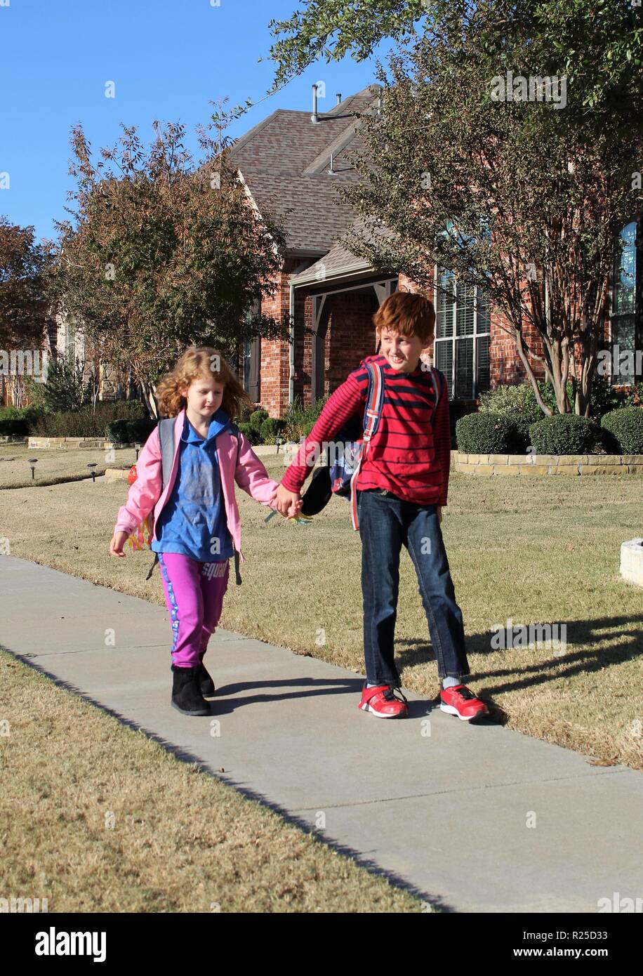 Fratello e Sorella di andare a scuola a piedi Foto Stock