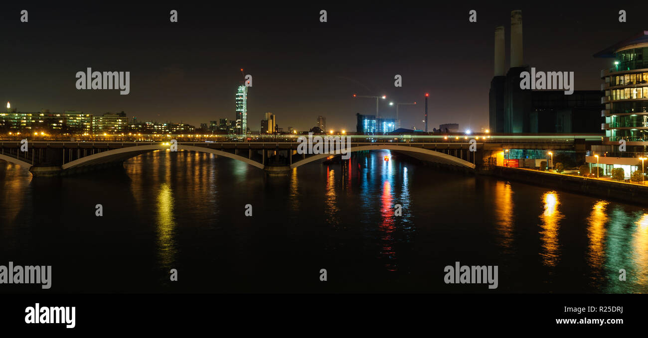 London, England, Regno Unito - 5 Marzo 2013: Treni blur come velocità di essi lontano dal London Victoria Station attraverso il Fiume Tamigi al di fuori di Battersea Power sta Foto Stock