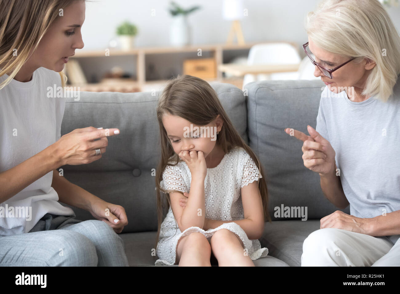 Arrabbiato madre e nonna scolding lezioni sconvolto kid girl t Foto Stock
