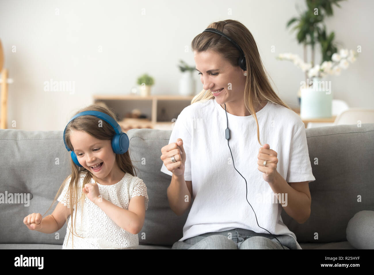 Felice la madre e il bambino figlia ascoltando musica in cuffia Foto Stock