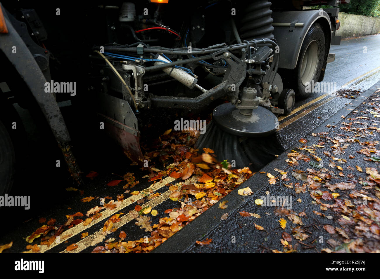 Un consiglio spazzatrice stradale mostrato di pulizia lascia lungo la strada a Chichester, West Sussex, Regno Unito. Foto Stock