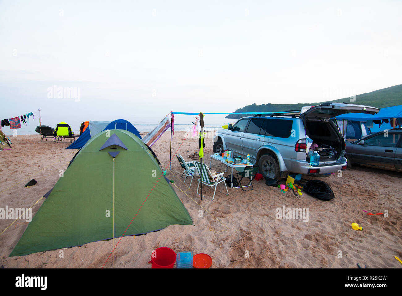 Automobile e camp sulla spiaggia la sera Foto Stock