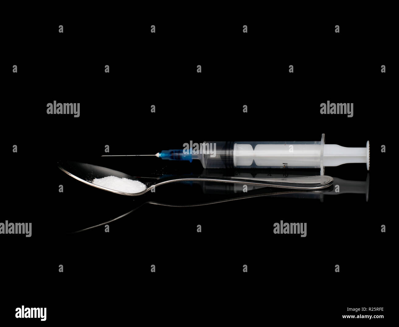 Polvere cristallina bianca farmaco, siringa e cucchiaio su sfondo nero. Dipendenza, la questione sociale. Foto Stock