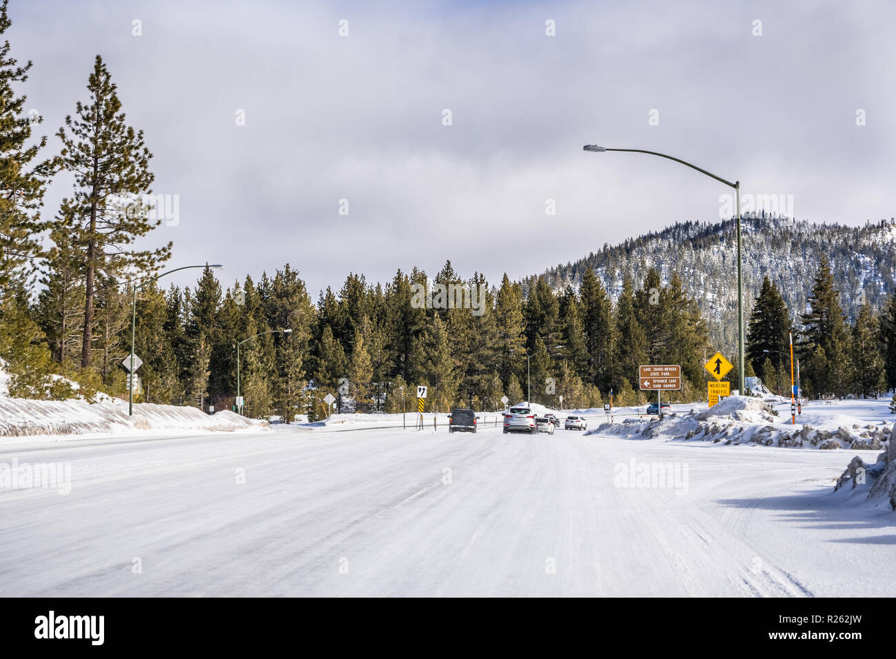 La guida su ghiaccio e neve coperto la strada attraverso le montagne di Sierra in una giornata di sole, Nevada Foto Stock