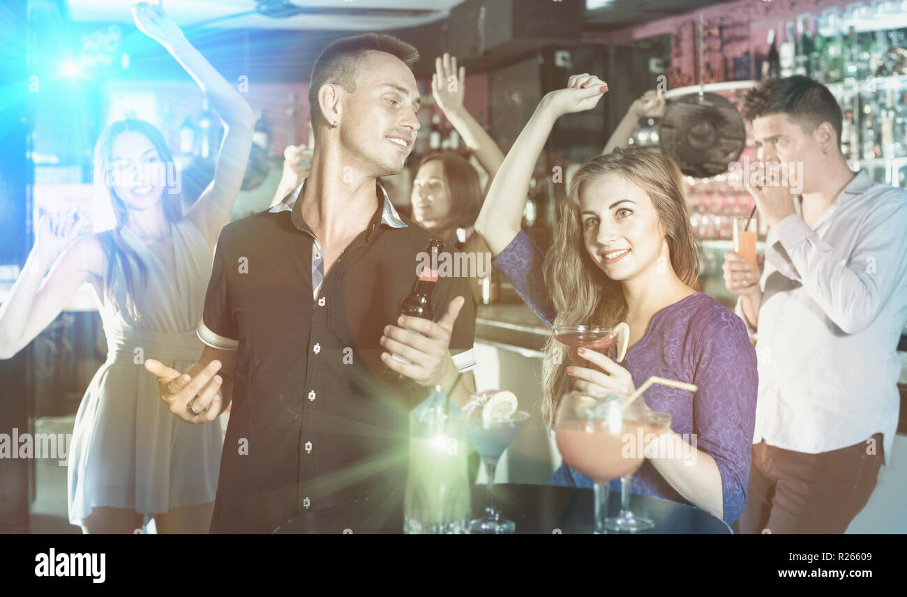 Sorridenti uomo con la donna sono bere un cocktail sulla corporate partito. Foto Stock