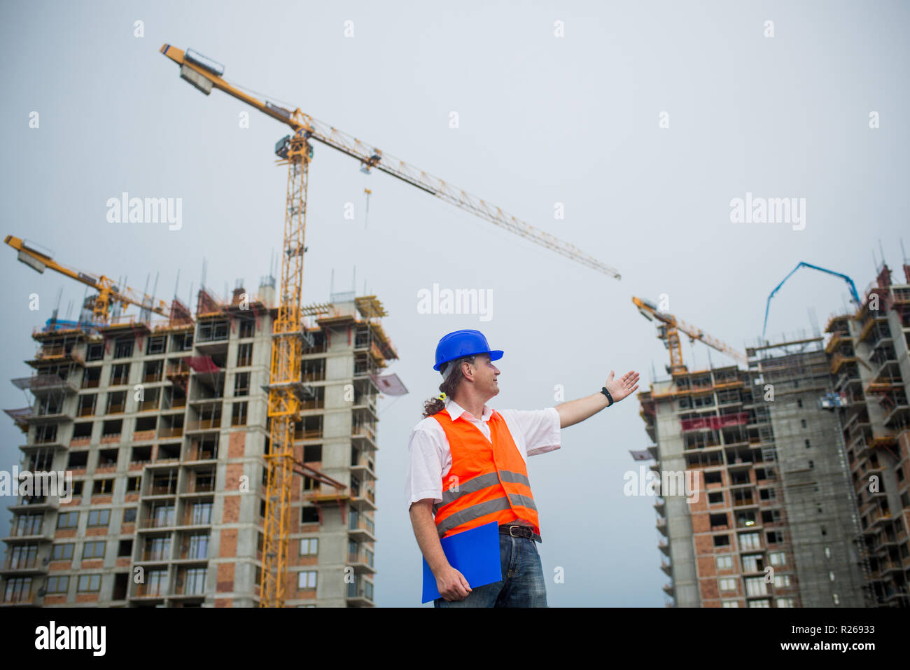 L'architetto che mostra gli edifici su un sito in costruzione durante un progetto di alloggiamento Foto Stock