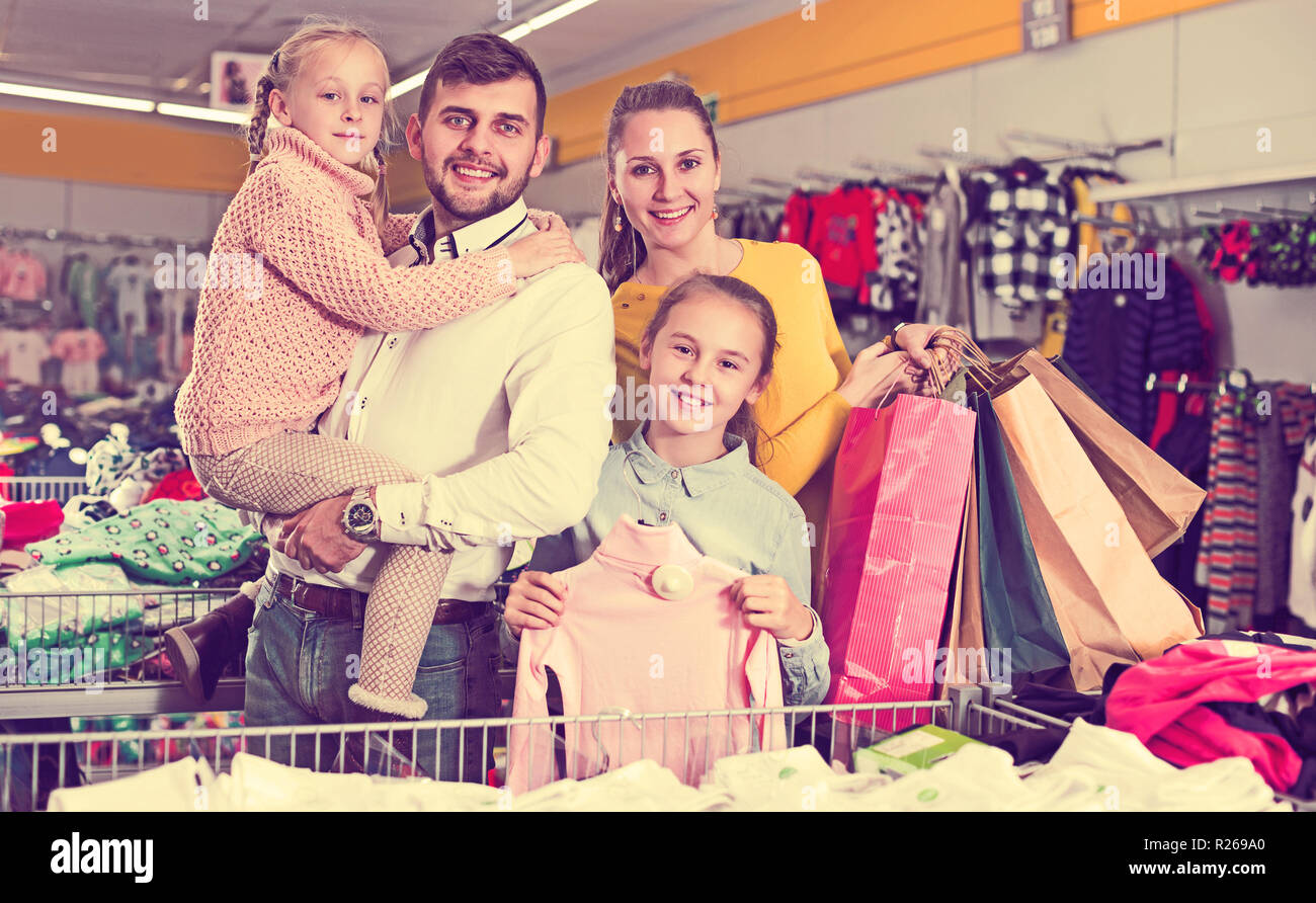 I genitori sorridente con due bambine durante la famiglia shopping Foto Stock