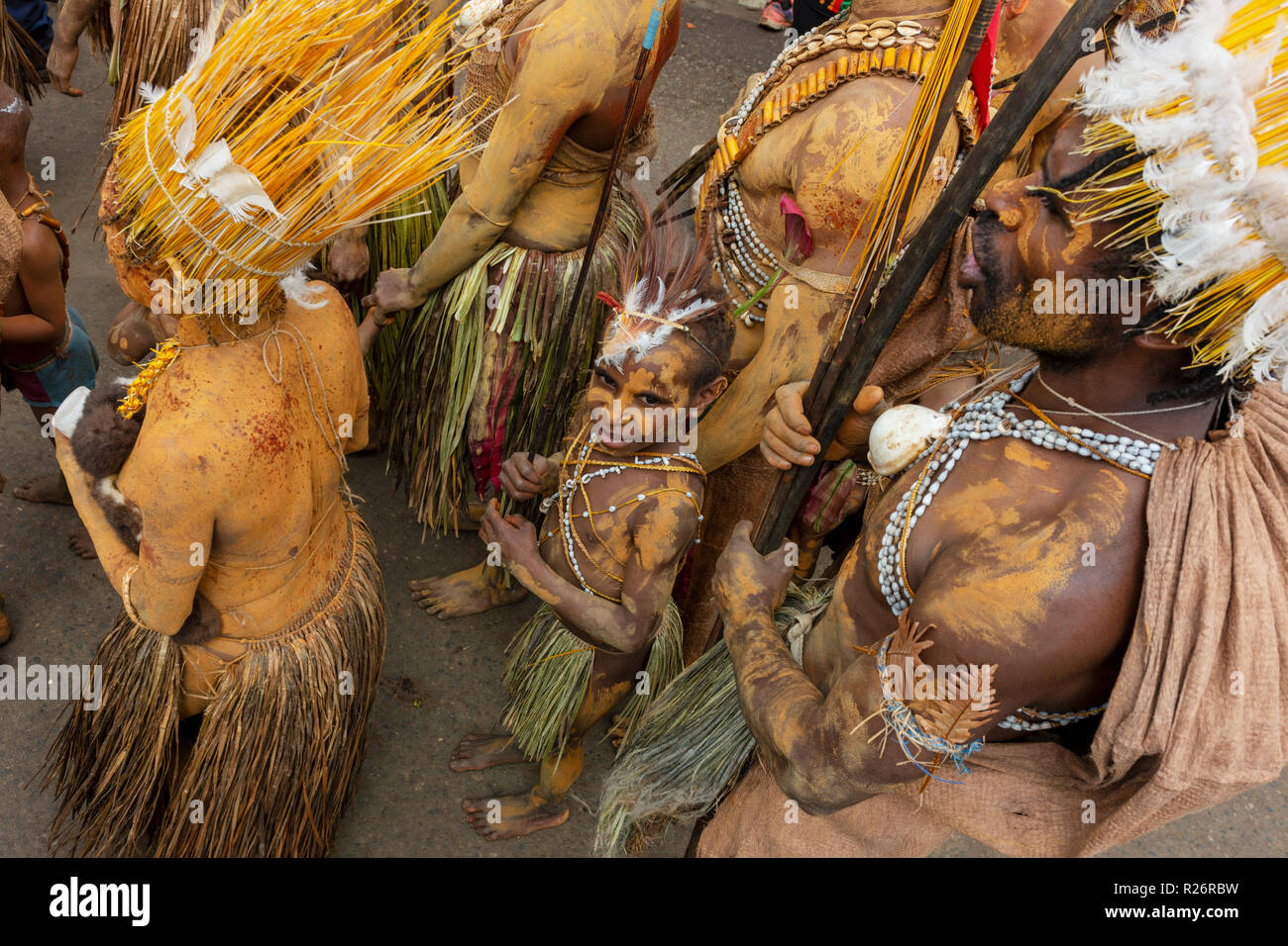 Un giovane ragazzo tra adulto esecutori al Festival di Goroka. Foto Stock