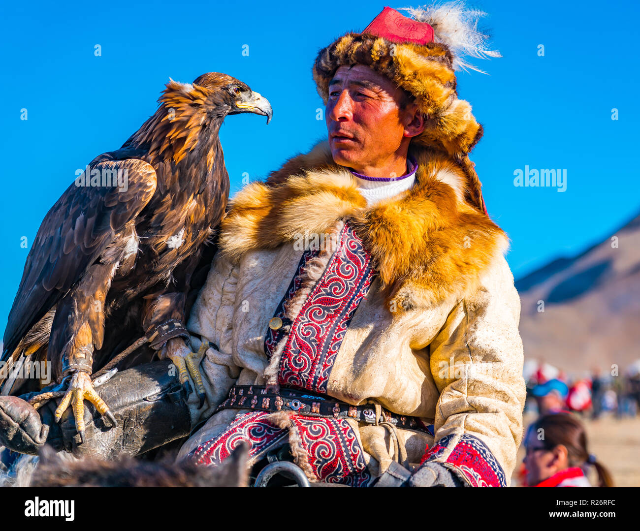 ULGII, MONGOLIA - Ottobre 6, 2018 : Golden Eagle Festival. Il Golden Eagle Hunter a cavallo guardando il ben addestrato eagle sulla sua mano al c Foto Stock