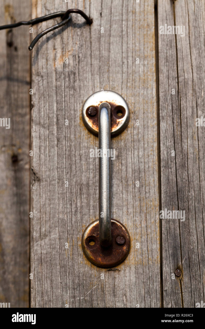 Vecchia maniglia in metallo e gancio, che ha chiuso la porta di legno del granaio, primo piano Foto Stock