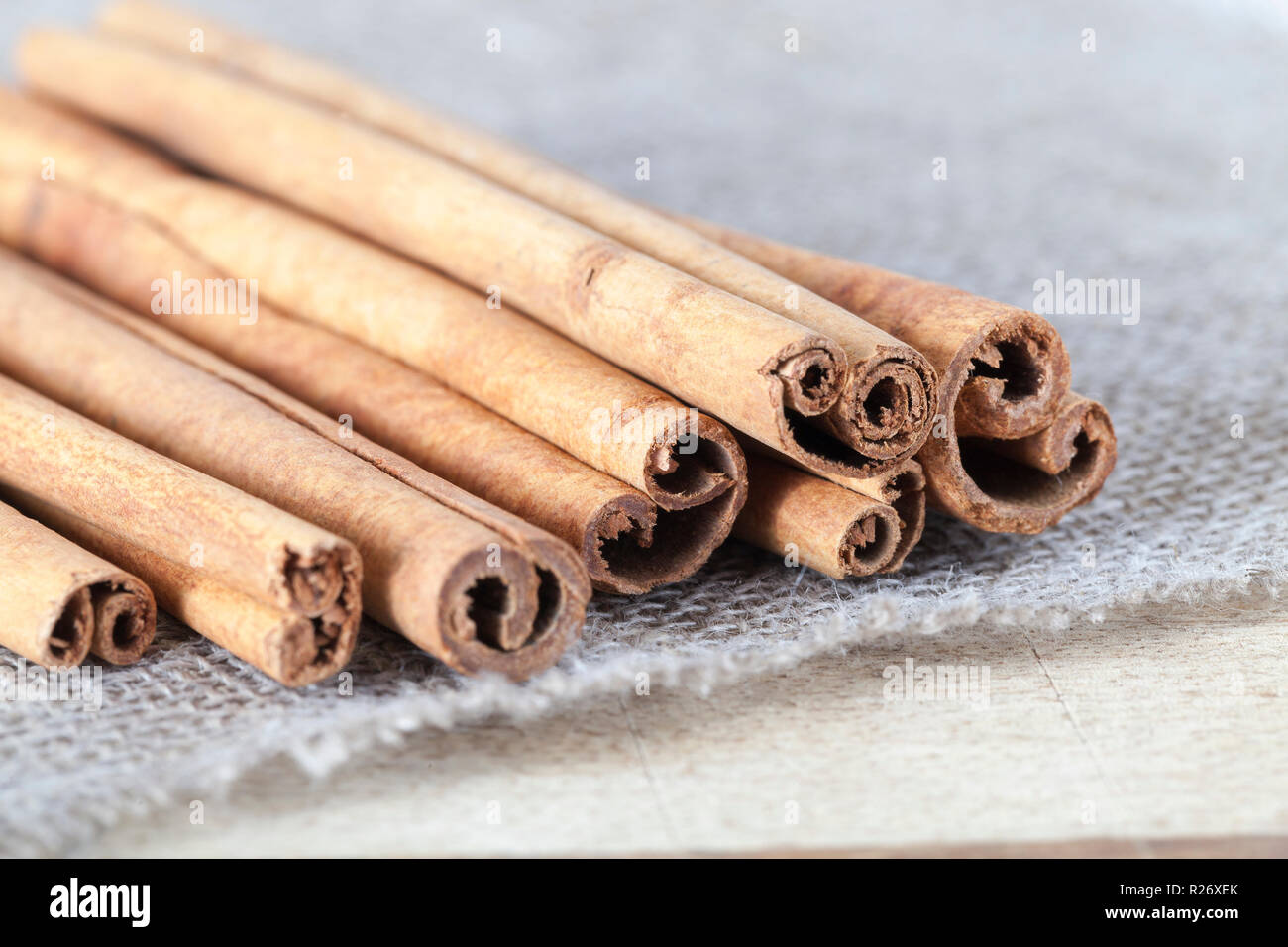 Cannella fragrante su un pezzo di tovaglie di lino su un tagliere di legno, tabella Dettagli in cucina Foto Stock