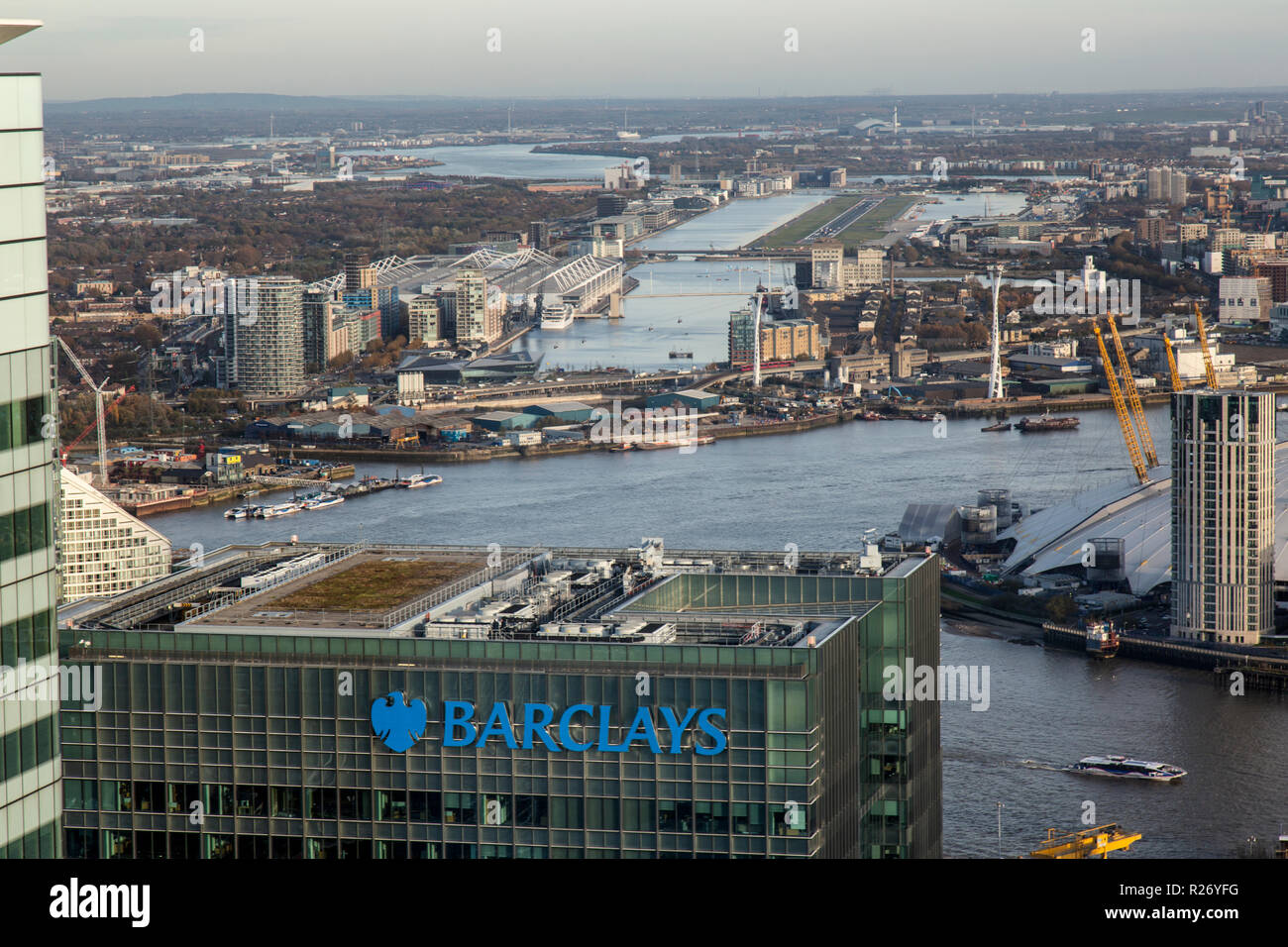 Vista guardando attraverso la parte superiore della Barclays Bank sede presso Churchill Luogo a Canary Wharf, Londra, con il London City airport in background. Foto Stock