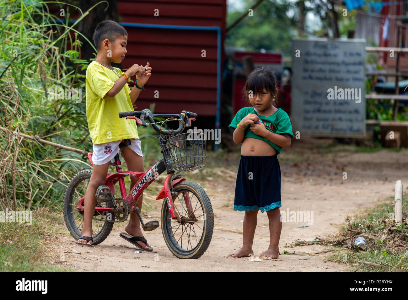 Don Det, Laos - Aprile 24, 2018: bambini locali su una bicicletta in un remoto villaggio del sud Laos Foto Stock
