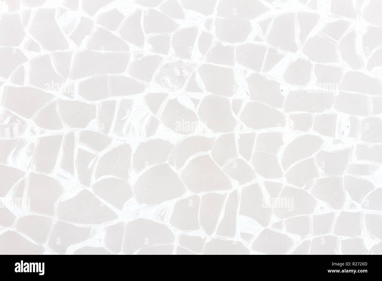 Parabrezza rotto texture in vetro su uno sfondo grigio. Il vetro rotto con il bianco di crepe. Foto Stock