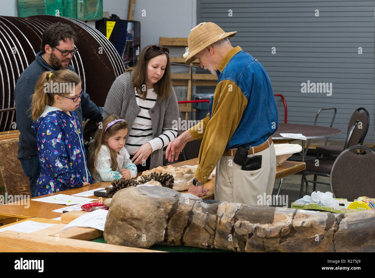 Un paleontologo che mostra i fossili di una visita a una famiglia con due ragazze. Umile, Texas, Stati Uniti d'America. Foto Stock