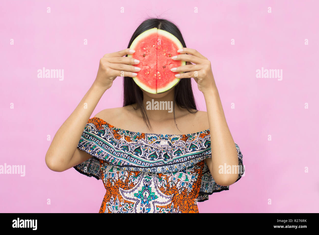 Ritratto di bella donna asiatica con cocomero isolato su sfondo rosa. Estate e vacanze Foto Stock