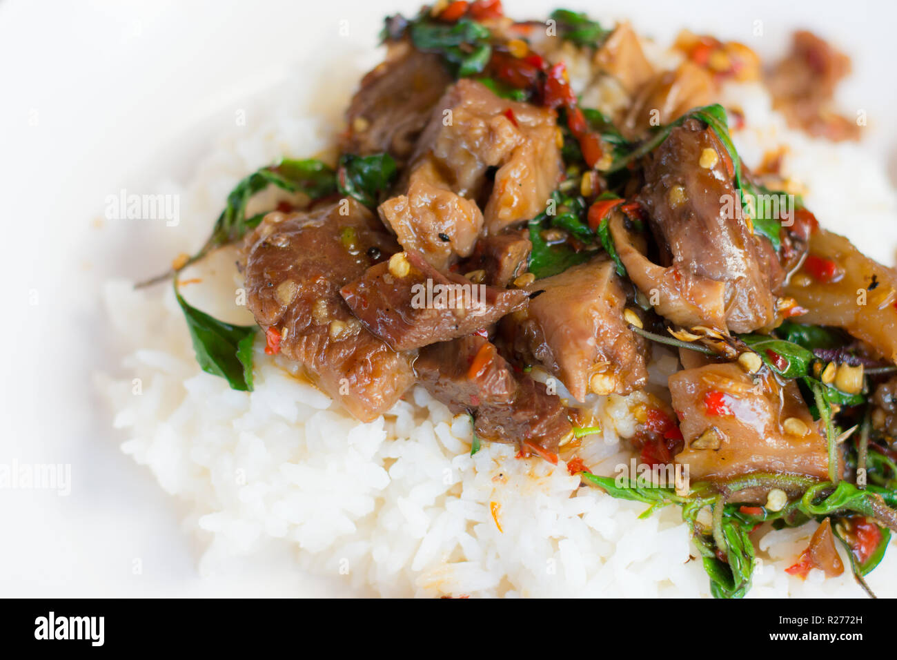 Stir-fritto di carne di maiale piccante con basilico santo sul riso ,cibo tailandese Foto Stock