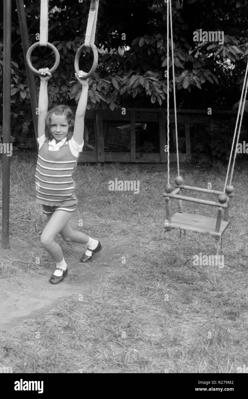 Ragazza giovane appesi da cerchiature in un parco degli anni settanta Ungheria Foto Stock