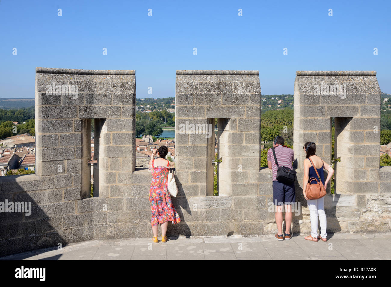 Tre turisti sulla terrazza sul tetto del Palazzo dei Papi o Palais des Papes guardando a vista su Avignone Provenza Francia Foto Stock