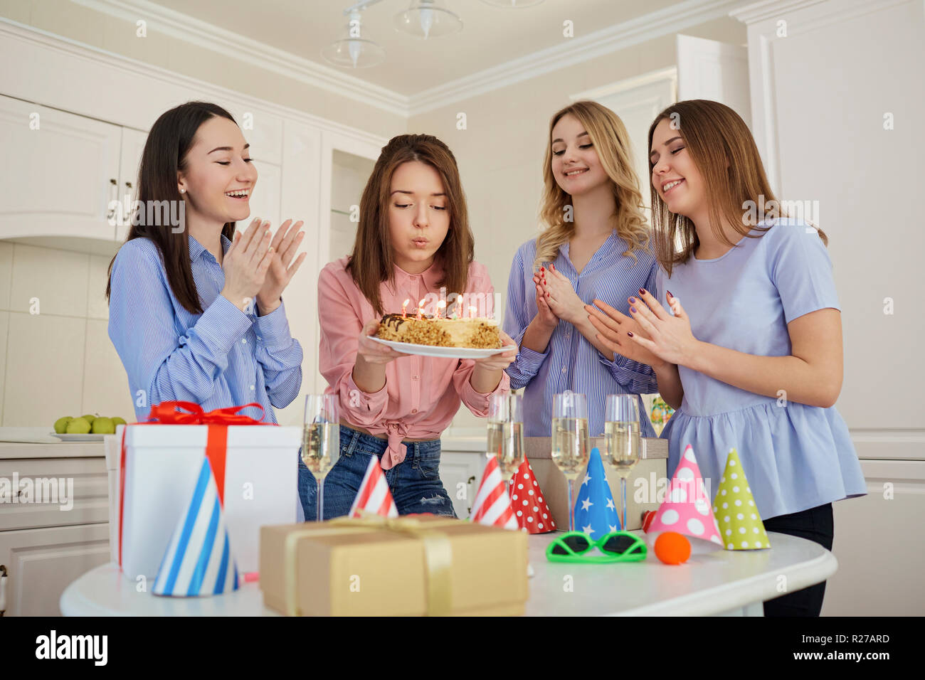 Un gruppo di amiche con una torta con candele di celebrare un birt Foto Stock