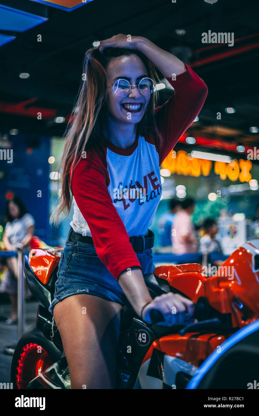 Una ragazza su una moto per divertirsi in un arcade in Ho Chi Minh City, Vietnam. Foto Stock