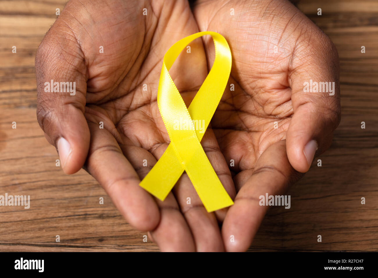 Persona della mano che tiene il nastro per il supporto di infanzia e cancro della vescica Foto Stock