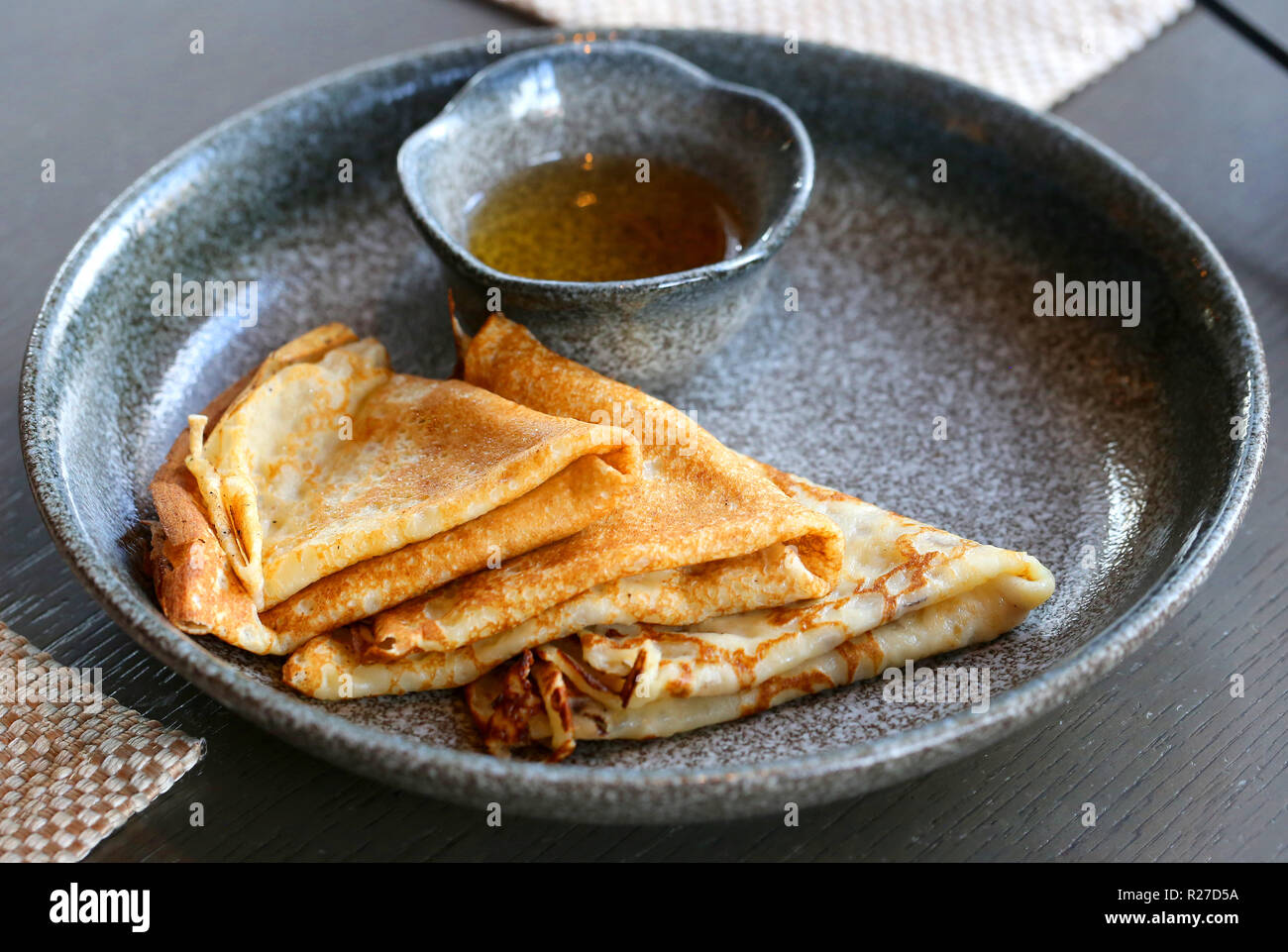 Foto macro di deliziose frittelle con miele al buio su un piatto in un ristorante Foto Stock