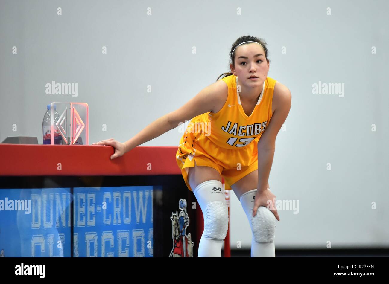 Dopo aver effettuato il check in presso il marcatore del tavolo, il giocatore entra in gioco come un giocatore substiture durante una scuola di gioco di basket. Stati Uniti d'America. Foto Stock
