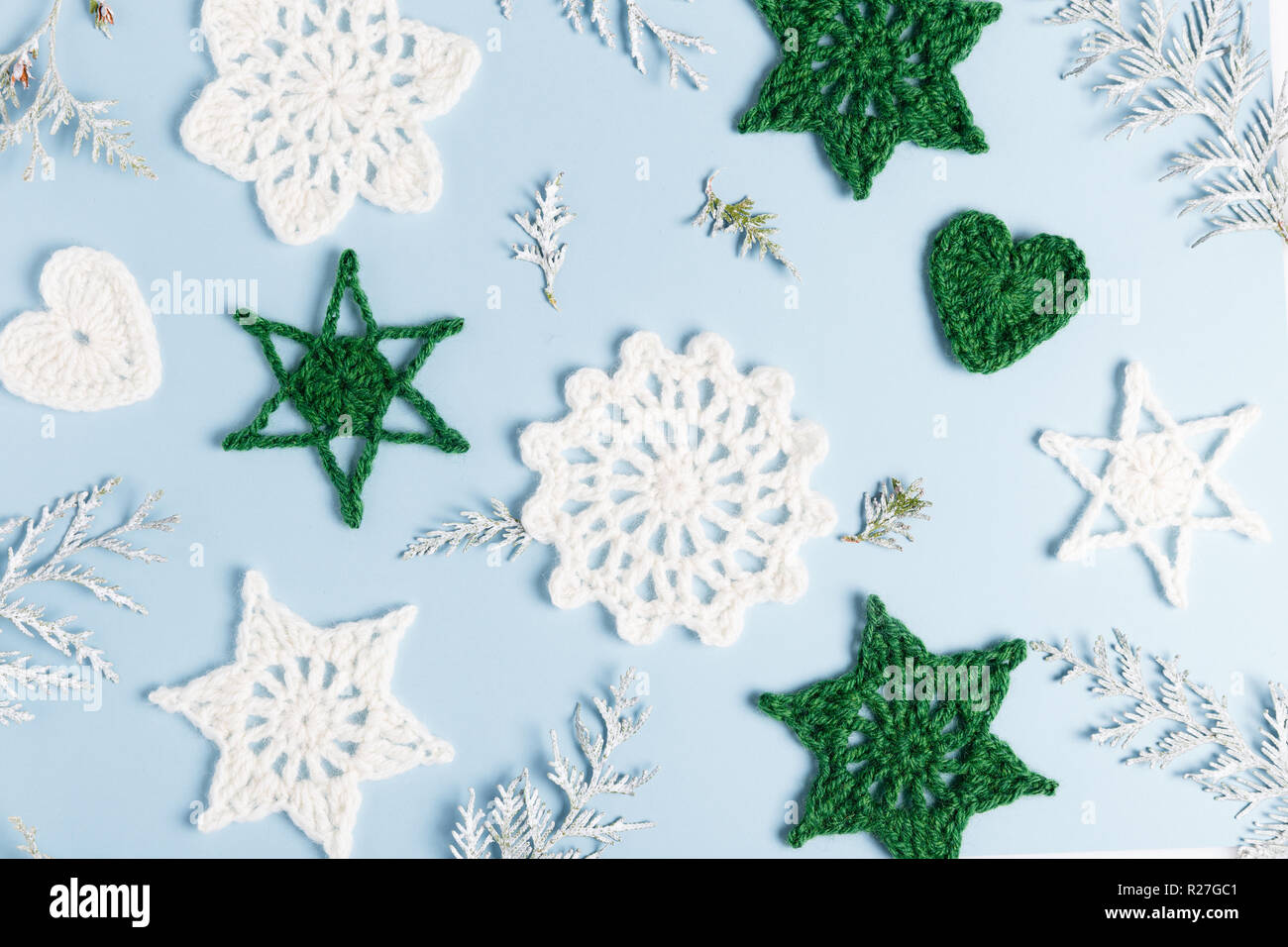 Composizione di natale di maglia fiocchi di neve bianca e stelle su sfondo bianco. Vista superiore, piana, laici copia spazio. Foto Stock