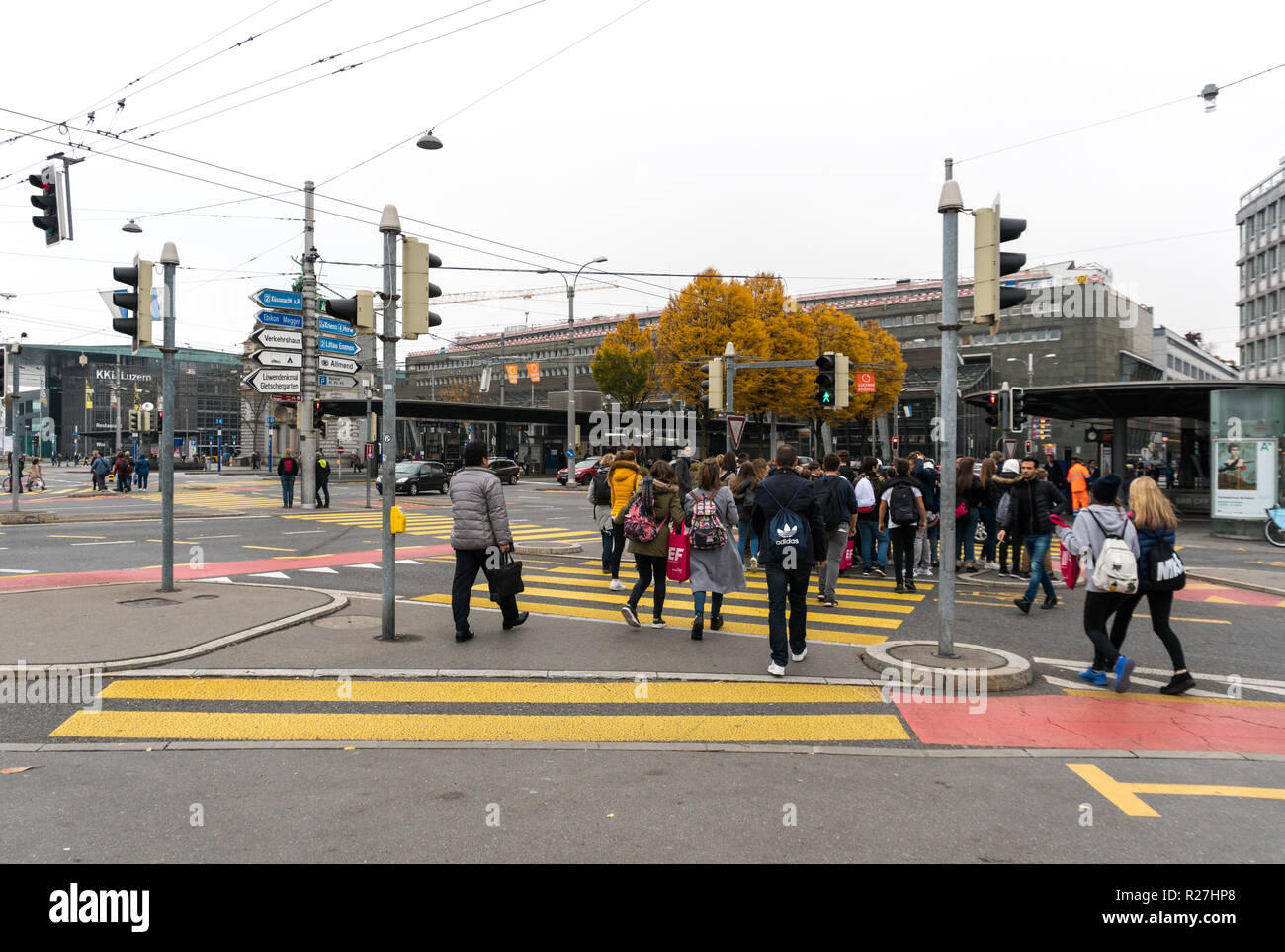 Lucerna, LU / Svizzera - 9 Novembre 2018: molti pedoni folla un incrocio isola in una strada trafficata e crosswalk durante le ore di punta in Lucerna ho Foto Stock