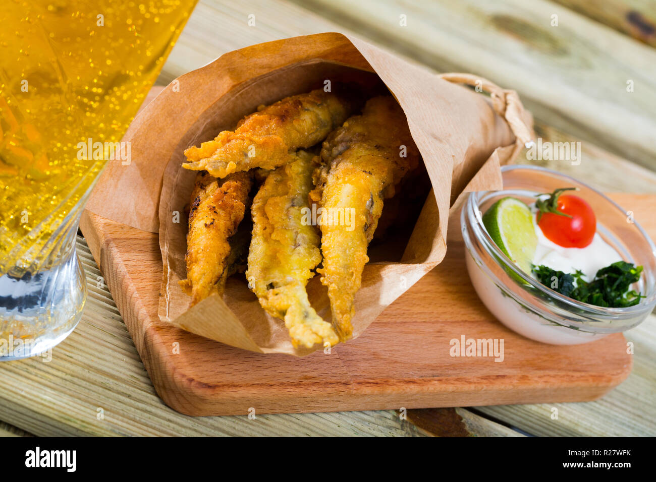 Pesce e patatine, martoriata spratti con la classica e cremosa salsa al formaggio e verdure Foto Stock