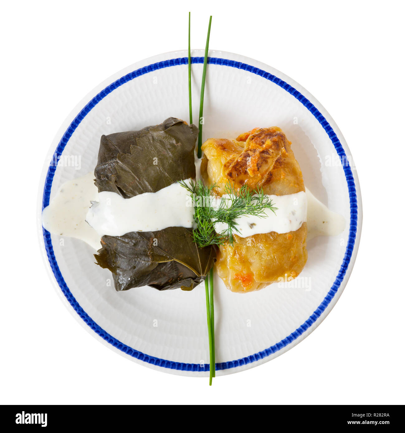 Vista superiore della deliziosa dolma e cavolo ripieno servito con panna acida e verdure fresche. Isolato su sfondo bianco Foto Stock