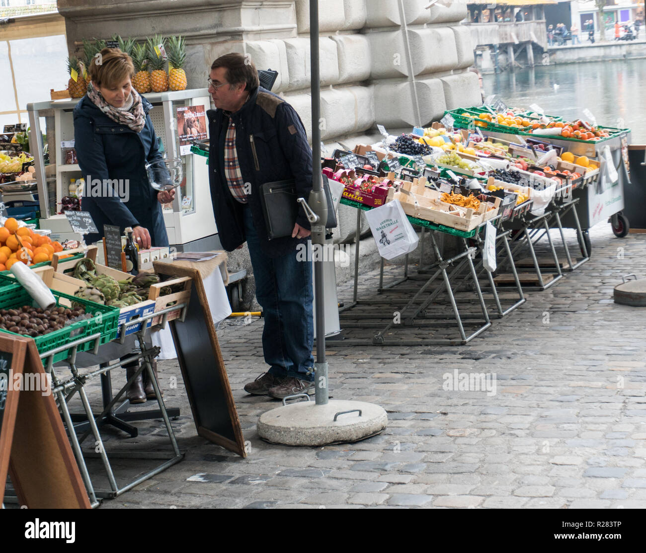 Lucerna, LU / Svizzera - 9 Novembre 2018: l'uomo l'acquisto di generi alimentari nella città di Lucerna a un open air mercato di frutta e verdura stand chiedere al negozio Foto Stock