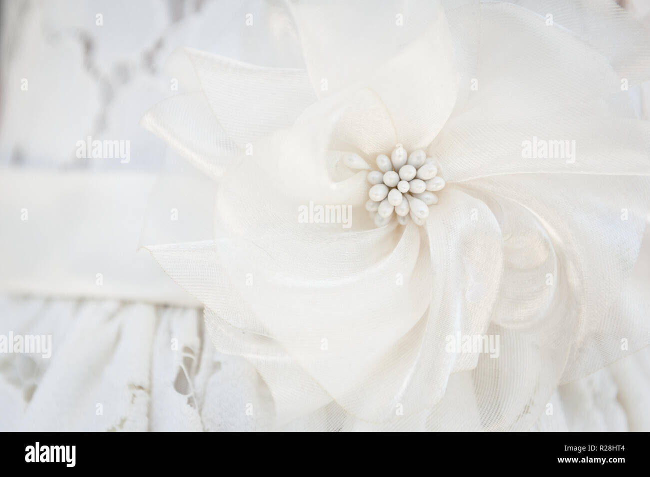 Uno sguardo più da vicino al dettaglio su un fiore ragazze vestito per un matrimonio. Foto Stock