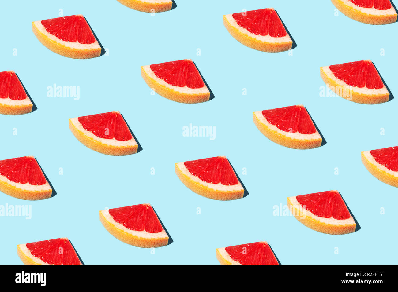 Bellissimo modello alimentare, alimenti fashion concept con la metà delle fette di pompelmo su sfondo blu. Foto Stock