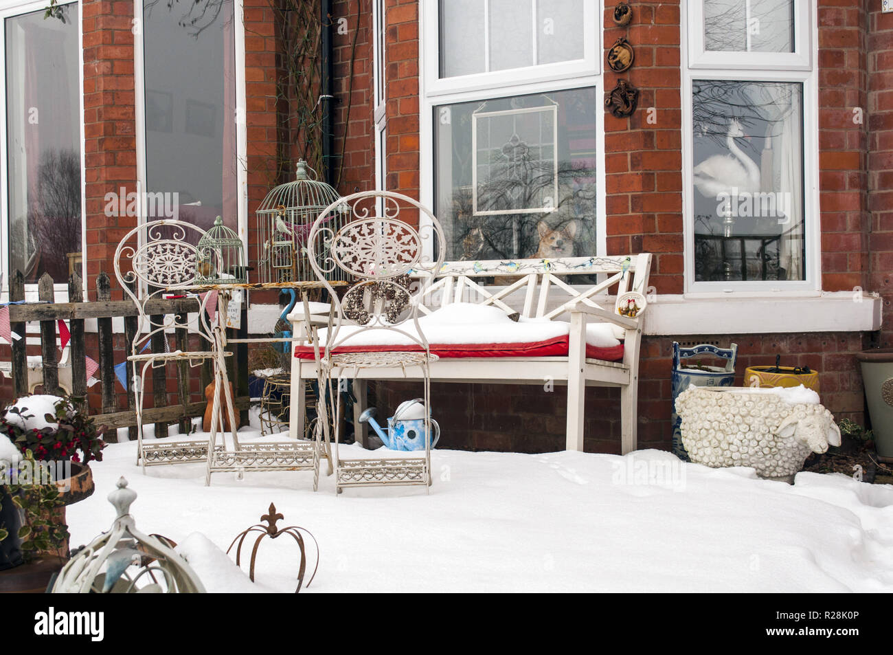 Una fantastica vista di un simpatico giardino con il banco e il mobilio e coperta di neve. Foto Stock