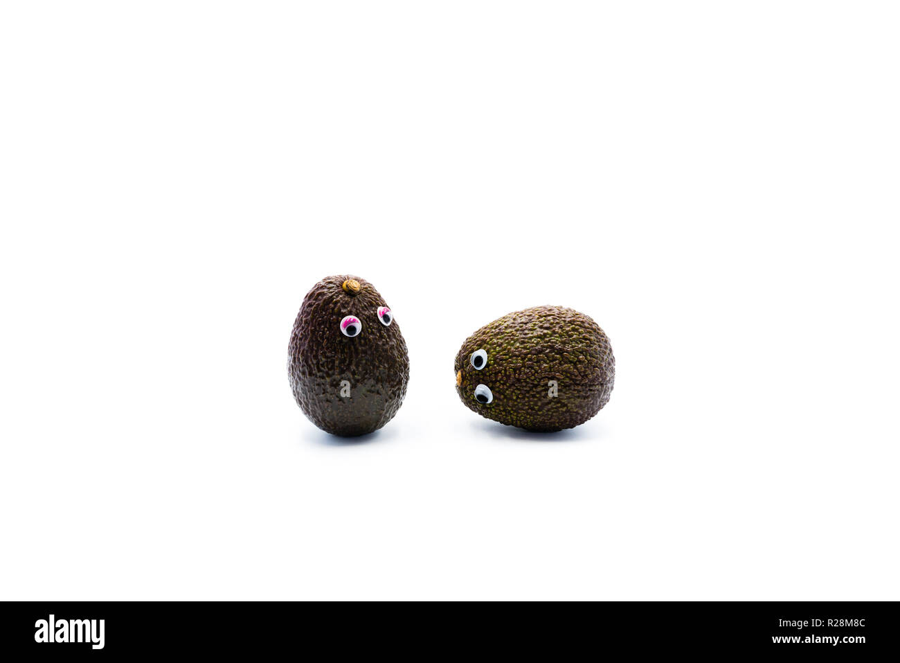 Romantico avocadi giovane con googly occhi come uomo e donna, funny food concept per progetti creativi. Foto Stock