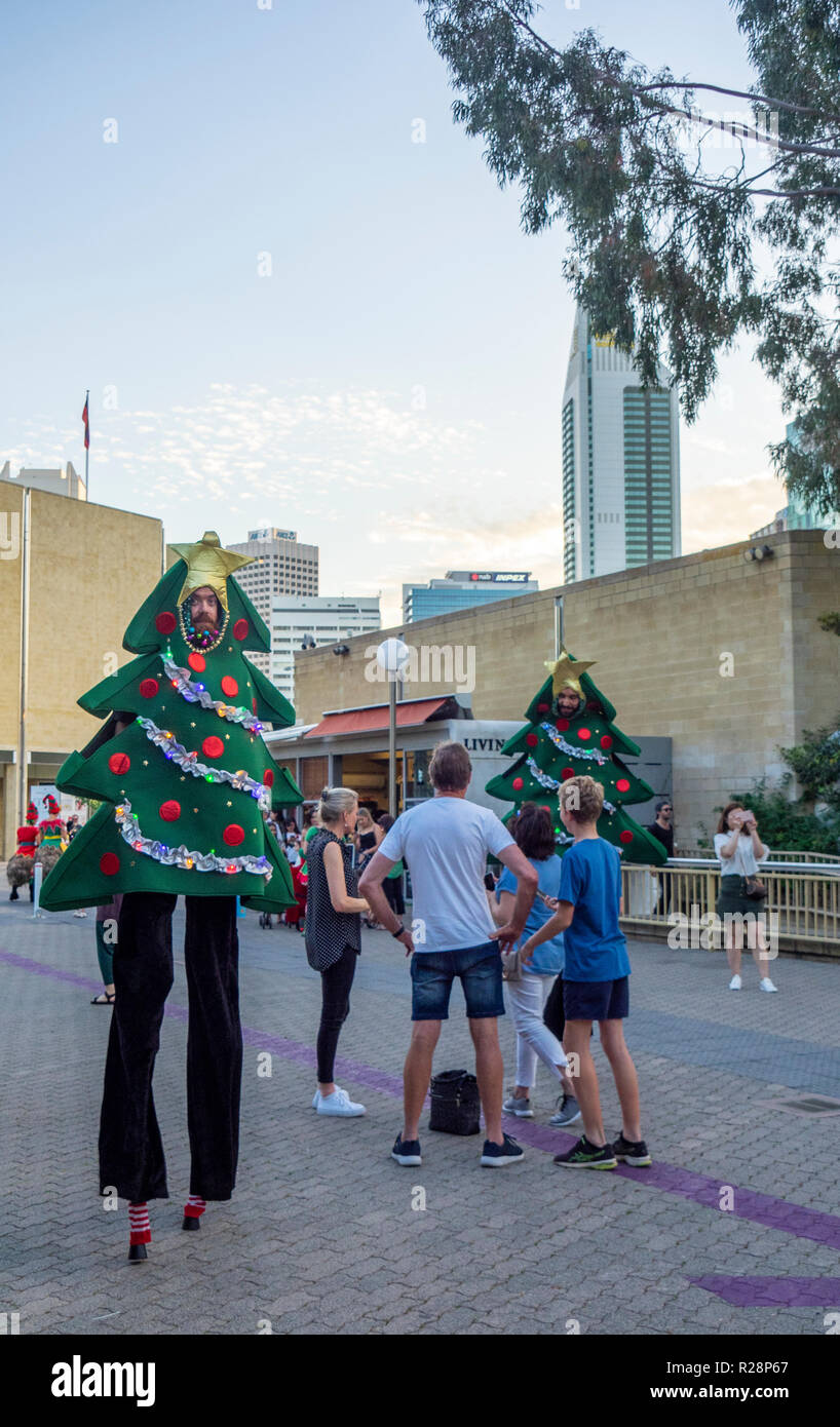 Attore nella struttura ad albero di Natale costume camminano su palafitte a Natale festival Perth Western Australia. Foto Stock