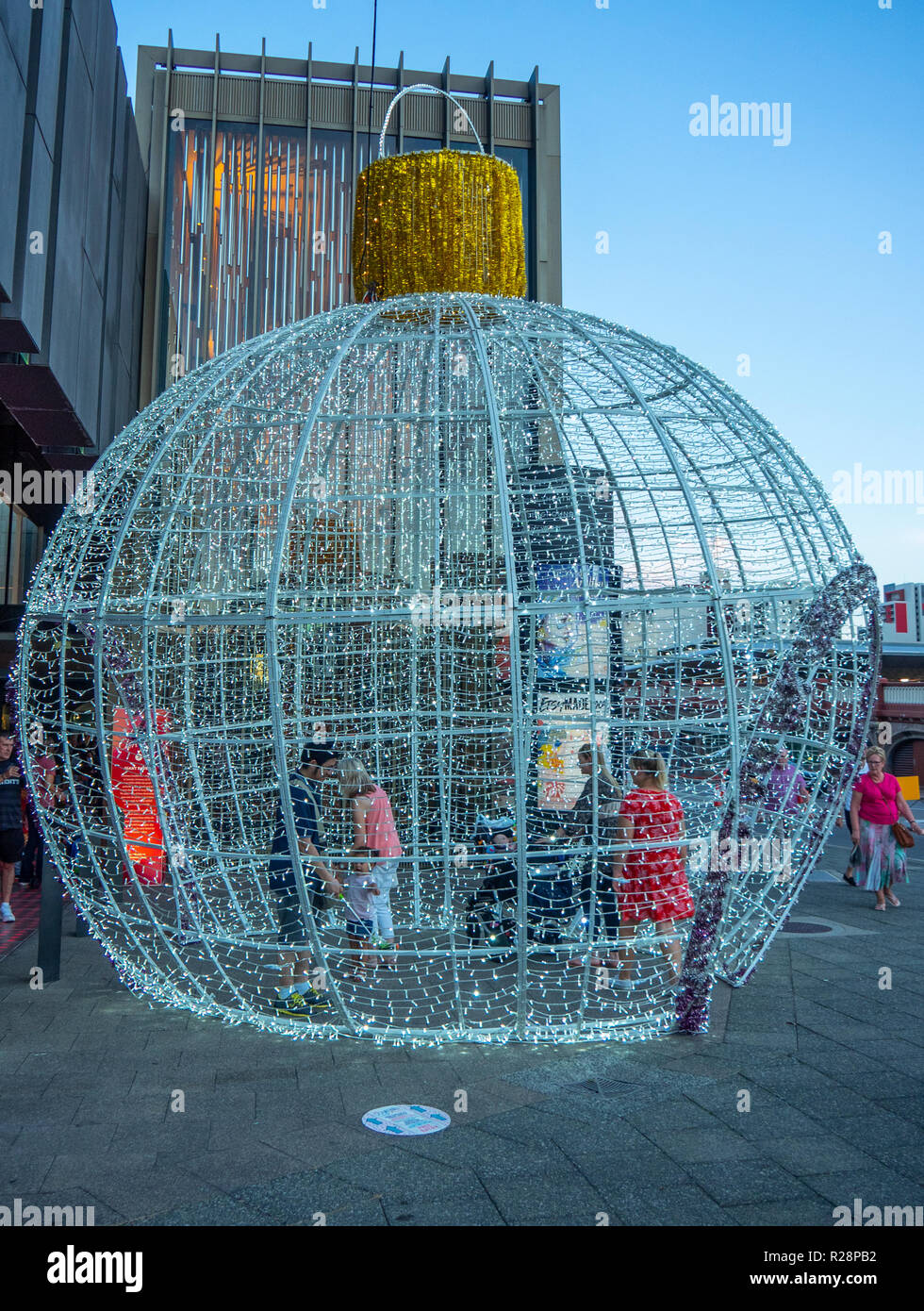 Persone in piedi all'interno di un gigante ninnolo Teatro di Stato centro di WA decorazioni natalizie Perth Western Australia. Foto Stock