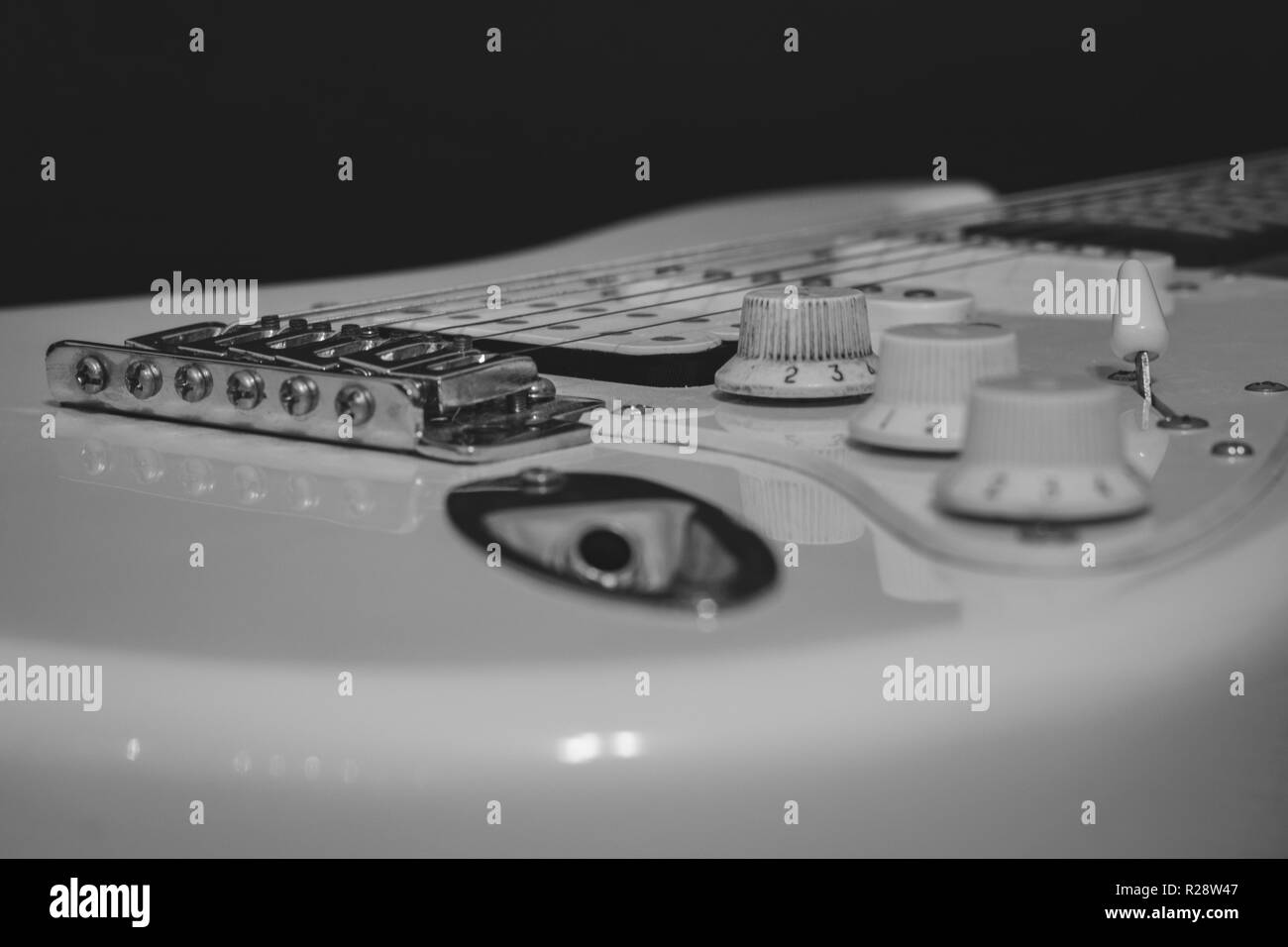 Bianco nero la musica rock concetto, solo filo elettrico chitarra con ponte, stringhe, del controllo di volume e di tono, rilevatori, jack di ingresso Foto Stock